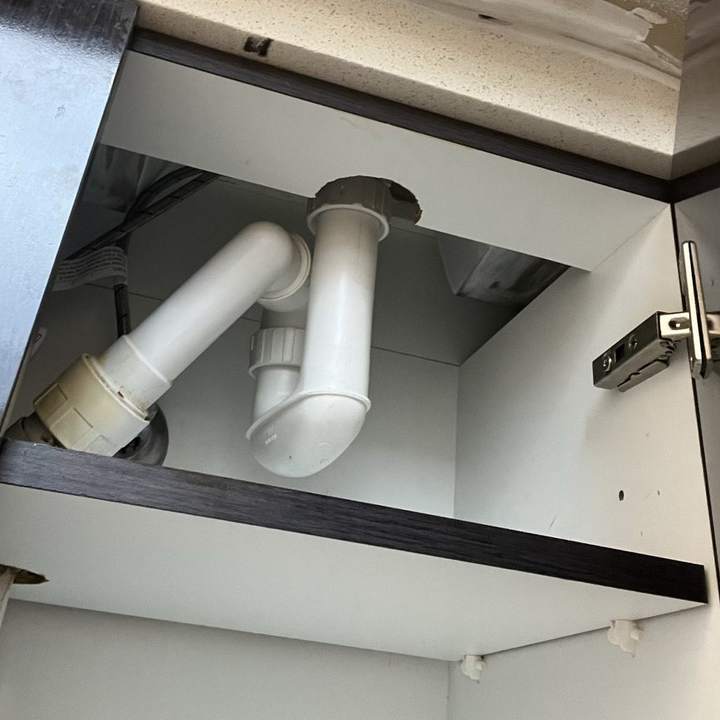 White waste pipe and trap under a bathroom vanity