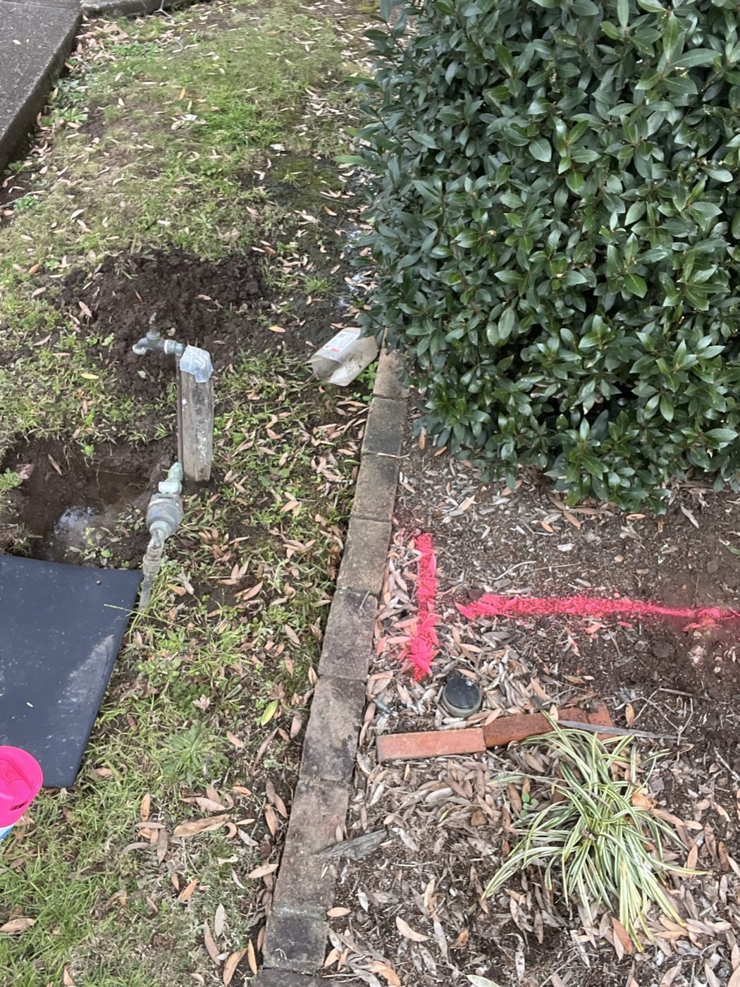 Marked ground and an exposed water line where a burst pipe was traced in Baulkham Hills