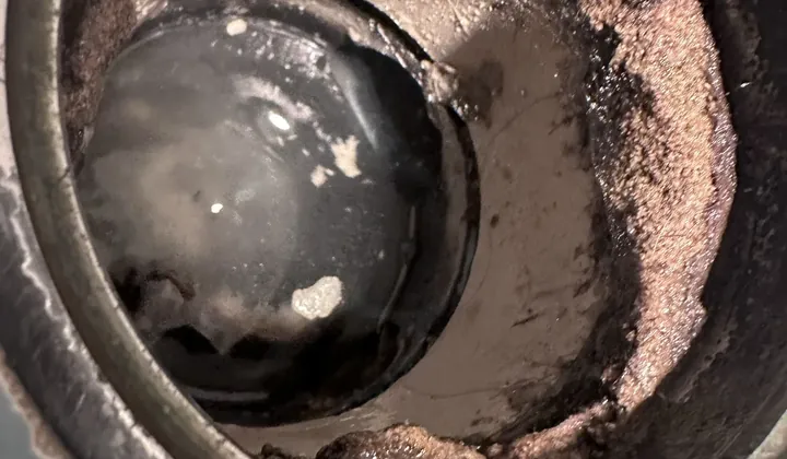 Drain outlet choked with built-up sludge and debris
