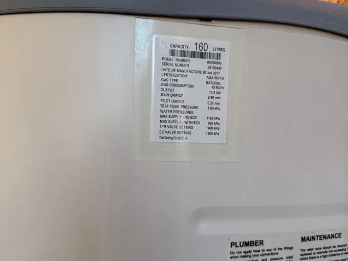 Data plate on a gas storage hot water system showing 160 litres and natural gas