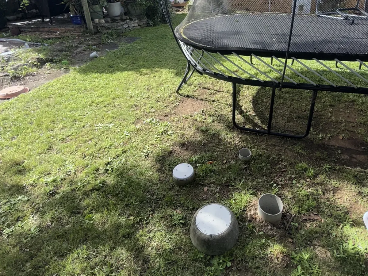 Sewer inspection openings on the back lawn beside a trampoline in Penrith