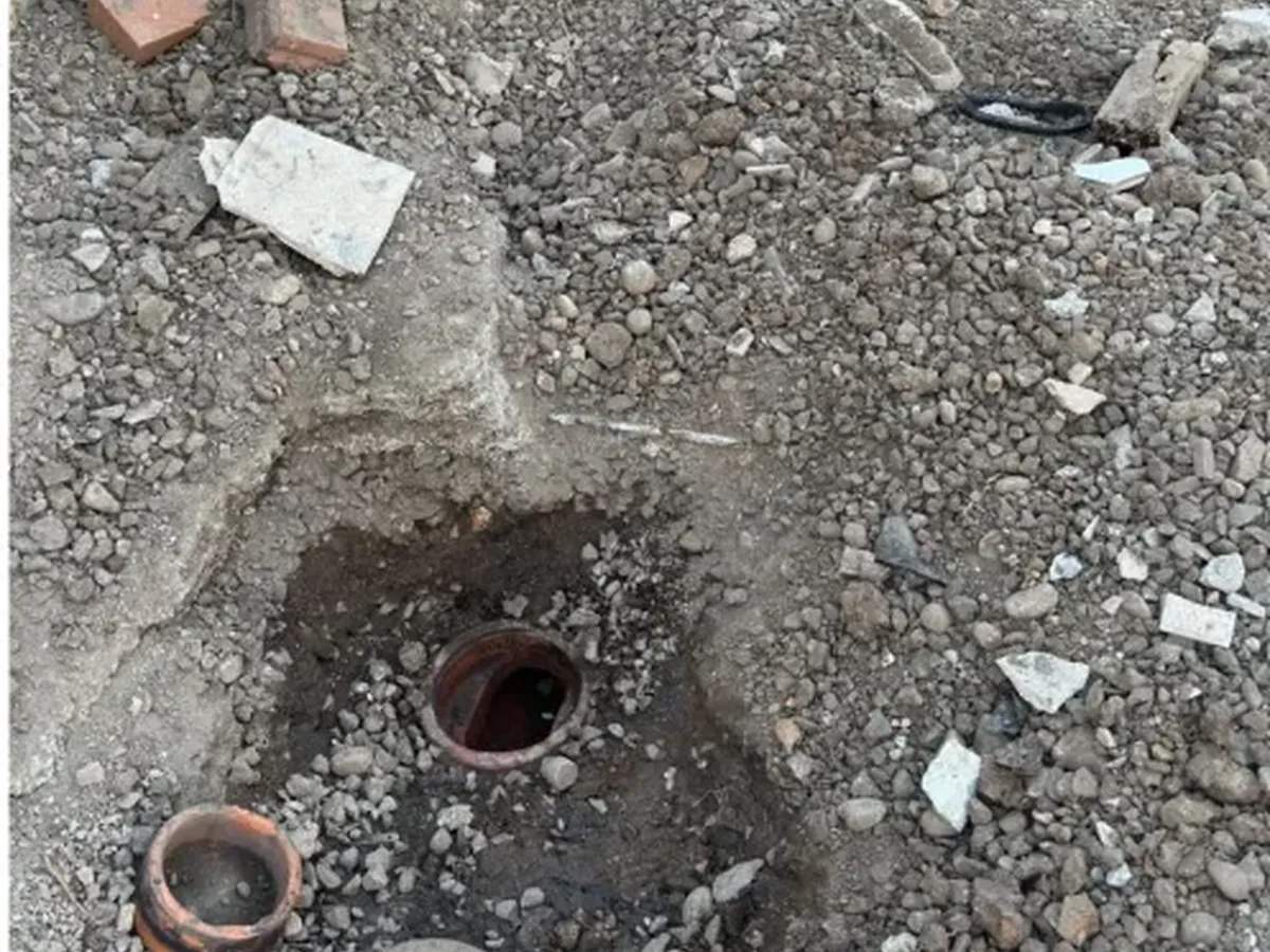 Sewer inspection opening dug out of the gravel in the backyard in Castle Hill