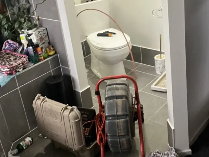 Jet blaster reel and tool case set up in the bathroom to clear a blocked drain in Edmondson Park