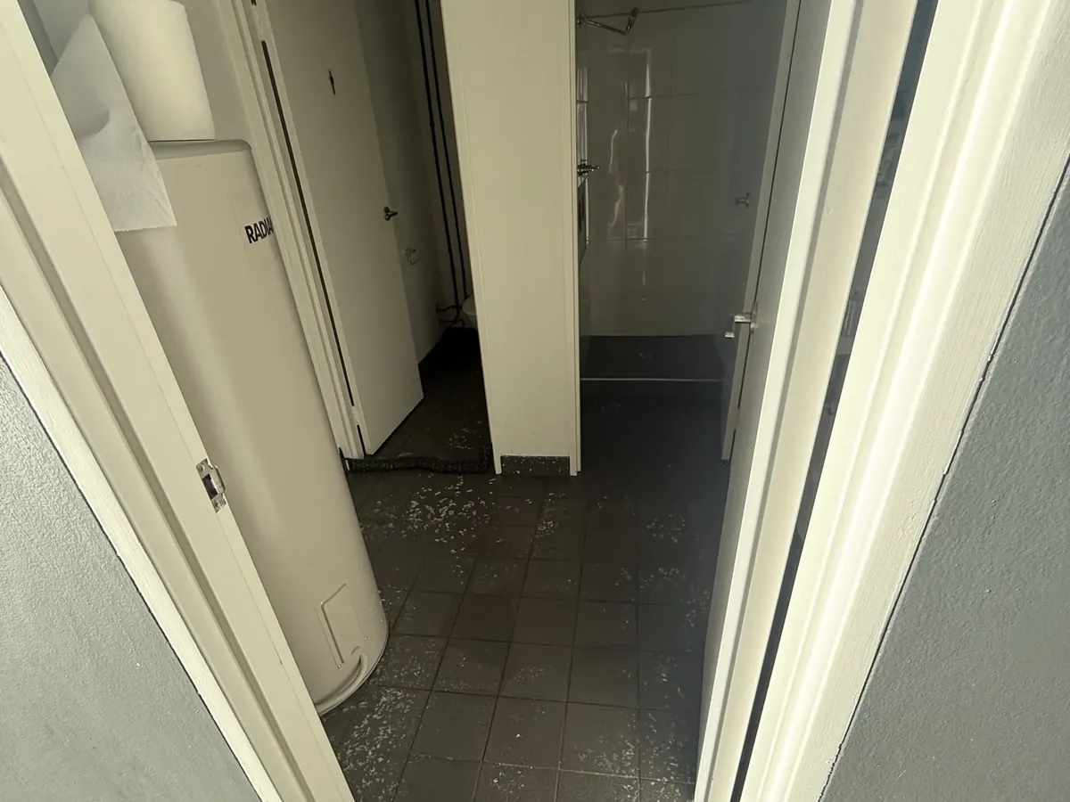 Water across the tiled floor of a hallway after a drain backed up inside in Minto