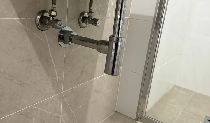 Chrome bottle trap under a wall-hung bathroom basin in Granville