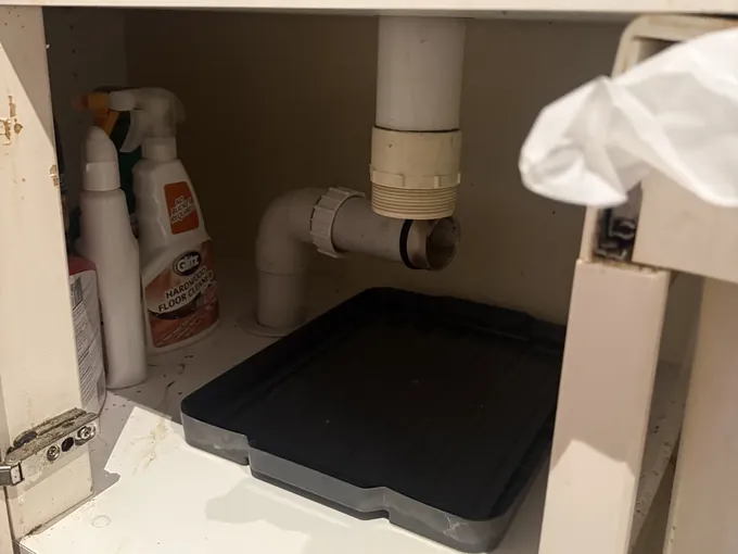 Sink waste pipe with the trap taken off under a cupboard in Erskineville