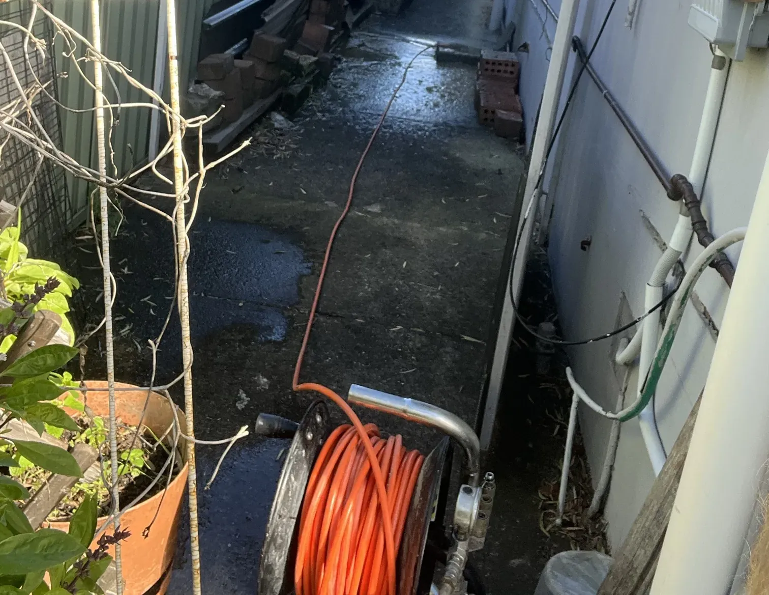 Jet blaster reel with the hose running up the wet side passage of a house in Belmore