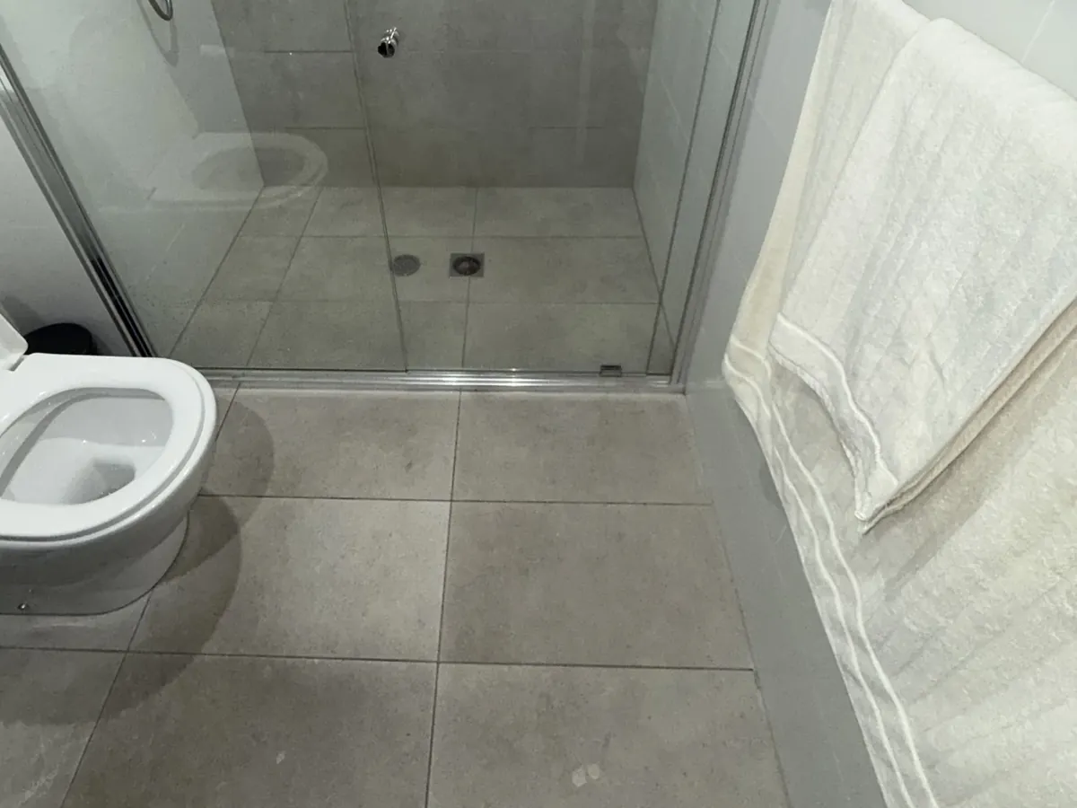 Walk-in shower and floor waste in a tiled bathroom in Belmore
