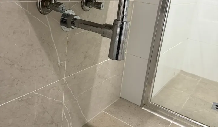 Chrome bottle trap and waste under a wall-hung bathroom basin in Granville