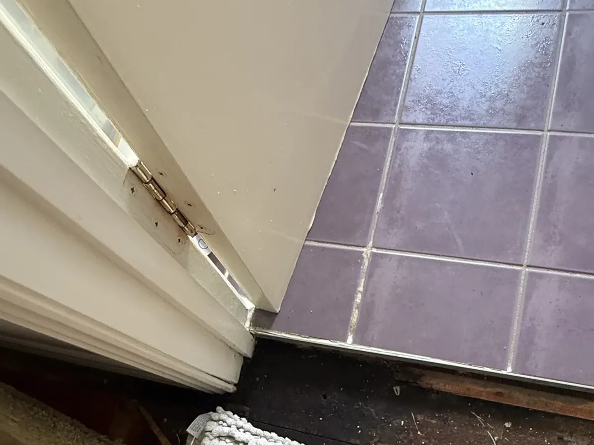 Carpet lifted at a bathroom doorway, showing the water-damaged floor underneath, in Green Valley