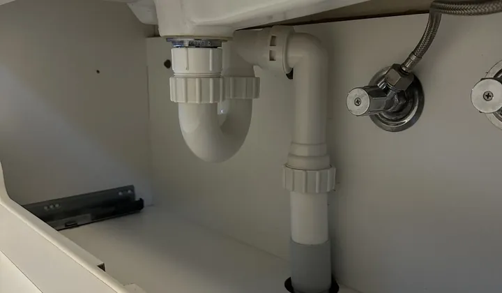 Braided flexi hose on an isolation tap inside a bathroom vanity in Glebe