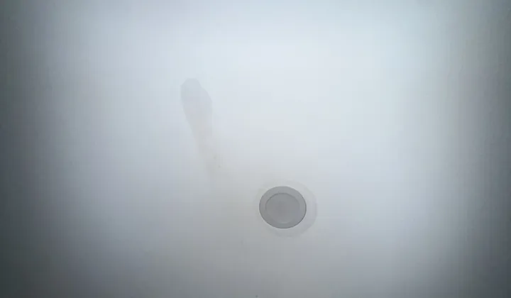 Water stain running across the ceiling beside a downlight in Beverly Hills