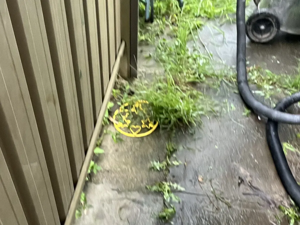 Water across the side path of a house with a pump set up beside the fence in Chester Hill