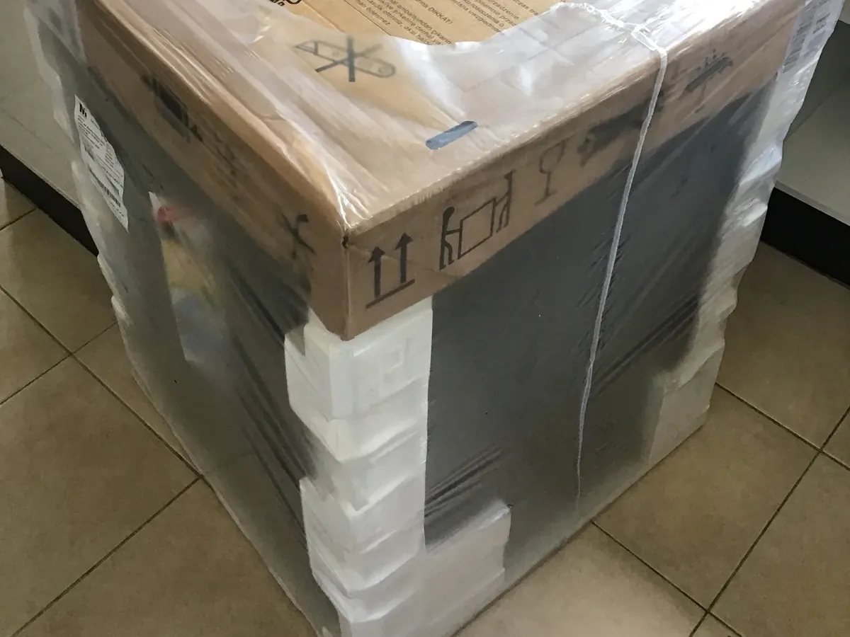 New dishwasher still wrapped in its packaging on a tiled kitchen floor in Oxley Park