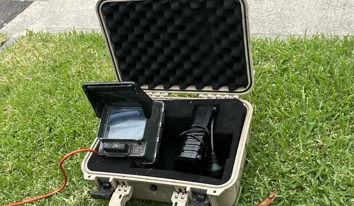 Drain camera monitor in its open carry case on a lawn beside a footpath in Gregory Hills