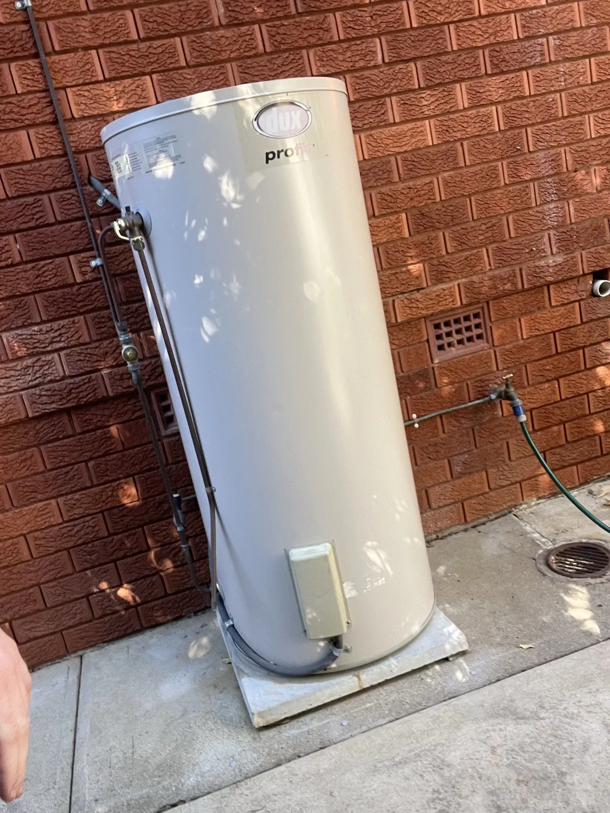 Dux Hot Water Sydney - Dux Proflo electric storage tank standing against a red brick wall in Blacktown