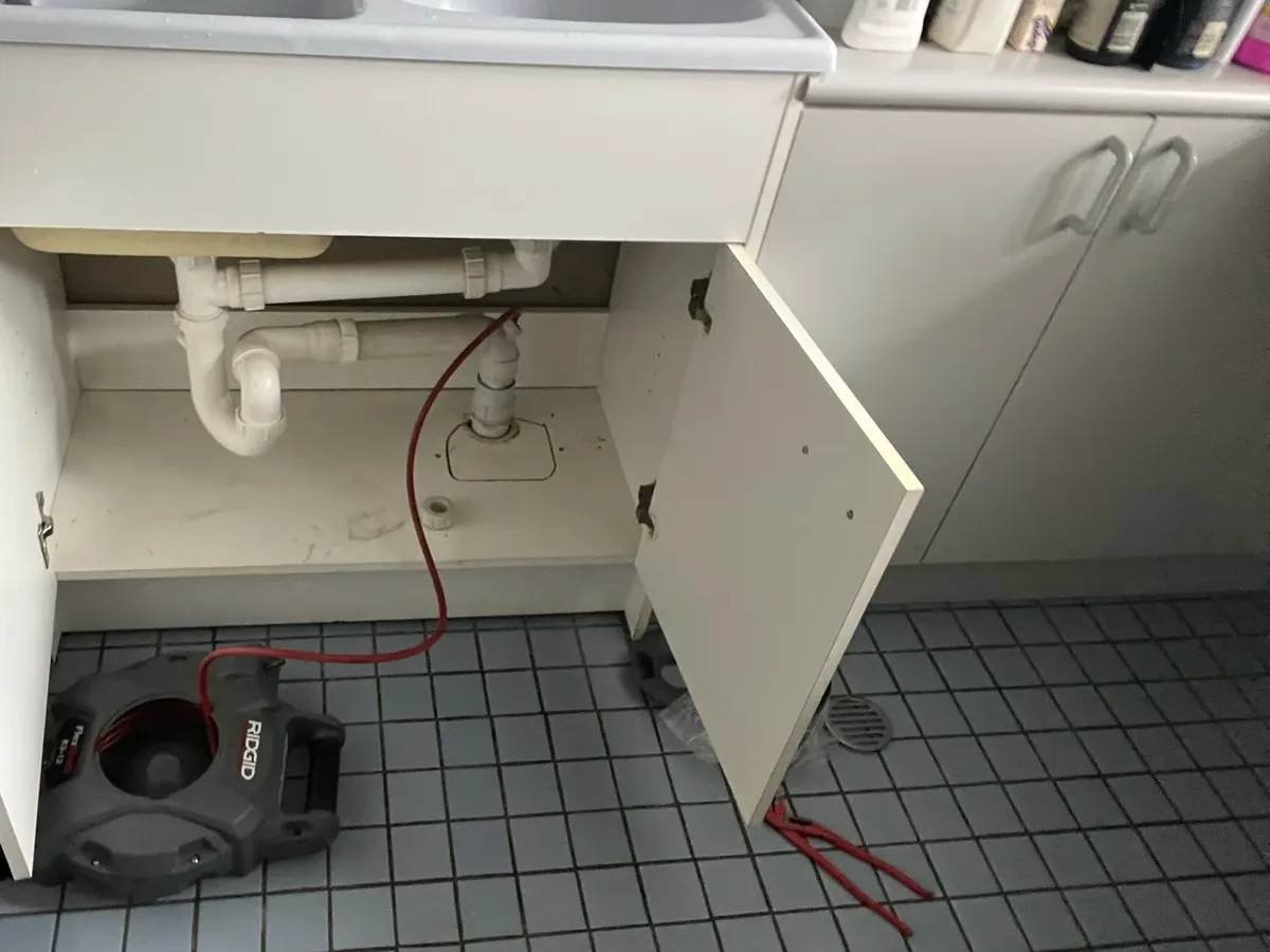 Drain machine cable run up into the waste pipe under a double laundry tub in Glebe