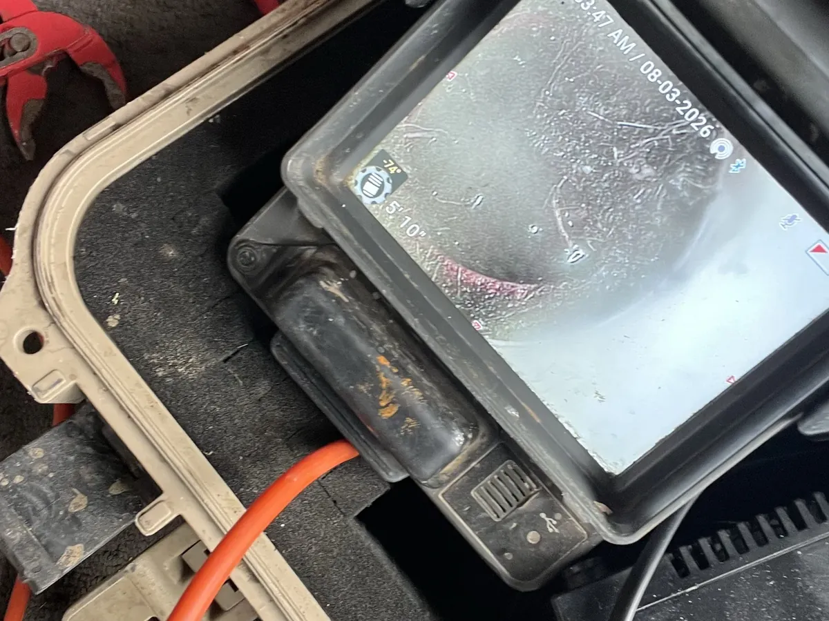 Drain camera monitor showing the inside of a blocked drain line, hand tools beside the case, in Villawood