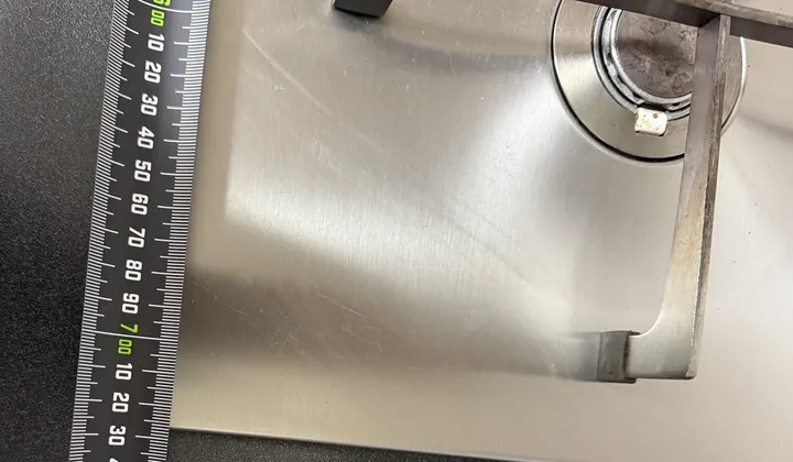 Measuring the benchtop beside a stainless gas cooktop in Bankstown