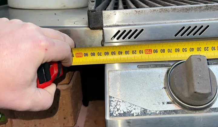 Tape measure held across the front of a built-in gas BBQ in Quakers Hill