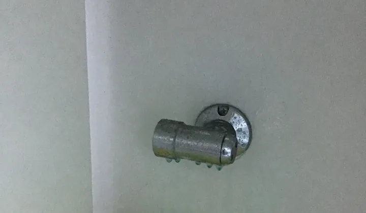 Blue leak test fluid on a chrome gas bayonet fitting on a white wall in Kellyville