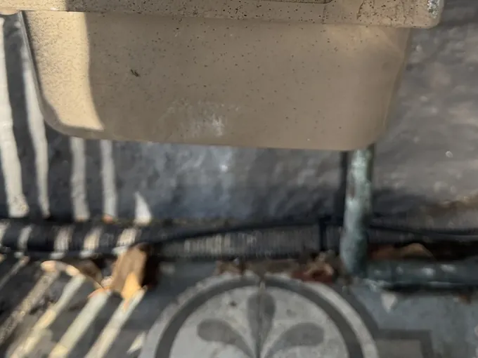 Gas meter body and its outlet pipework above a tiled path in Surry Hills