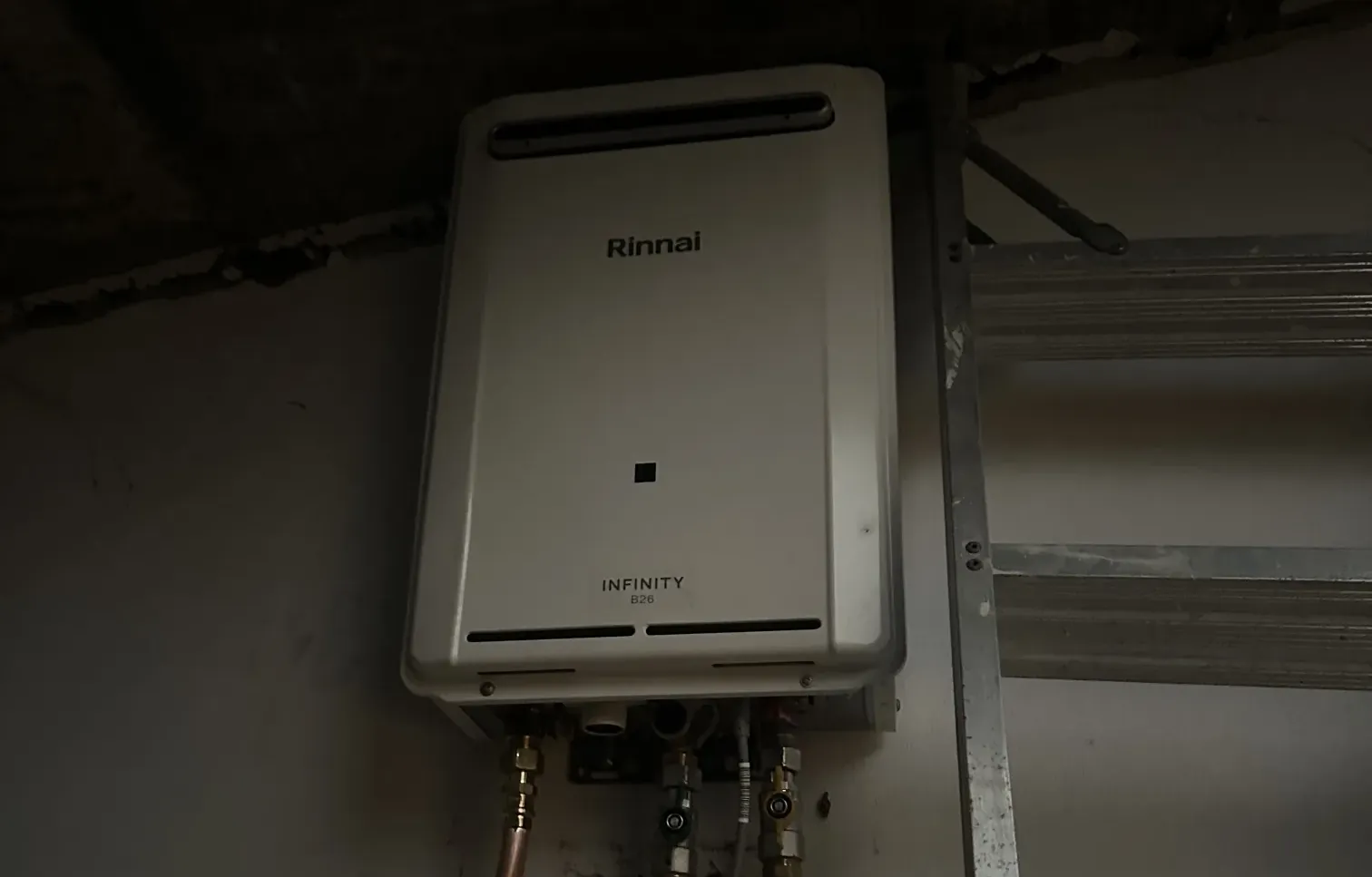 Continuous flow gas hot water unit with copper pipes and isolation valves under a covered overhang in Beacon Hill