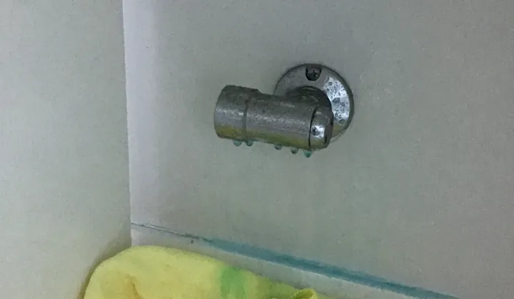 Chrome gas bayonet point inside a white cupboard with beads of leak test fluid on the fitting, in Kellyville