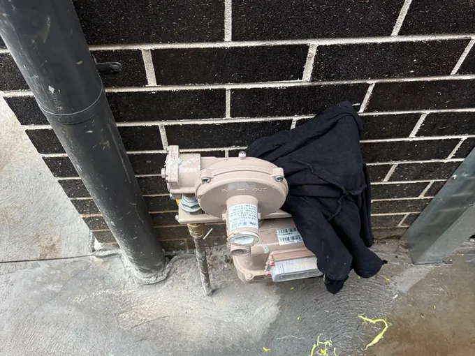 Gas meter and regulator at the wall where a new gas run would connect in Carramar