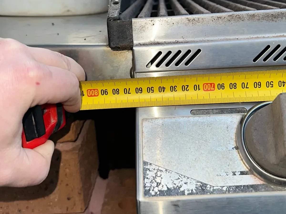 Tape measure held across the front of a built-in gas BBQ in Quakers Hill