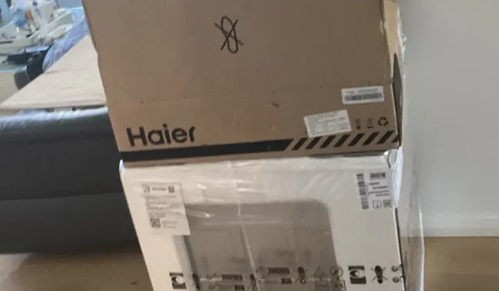 New kitchen appliances still in their boxes, stacked in a living room in Spring Farm