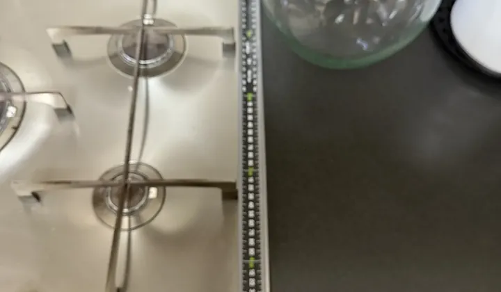 Tape measure laid beside a stainless gas cooktop on a dark benchtop in Bankstown