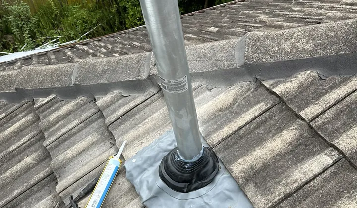 New flue pipe with flashing fitted through a tiled roof
