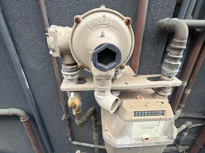 Gas regulator and meter on a dark painted wall