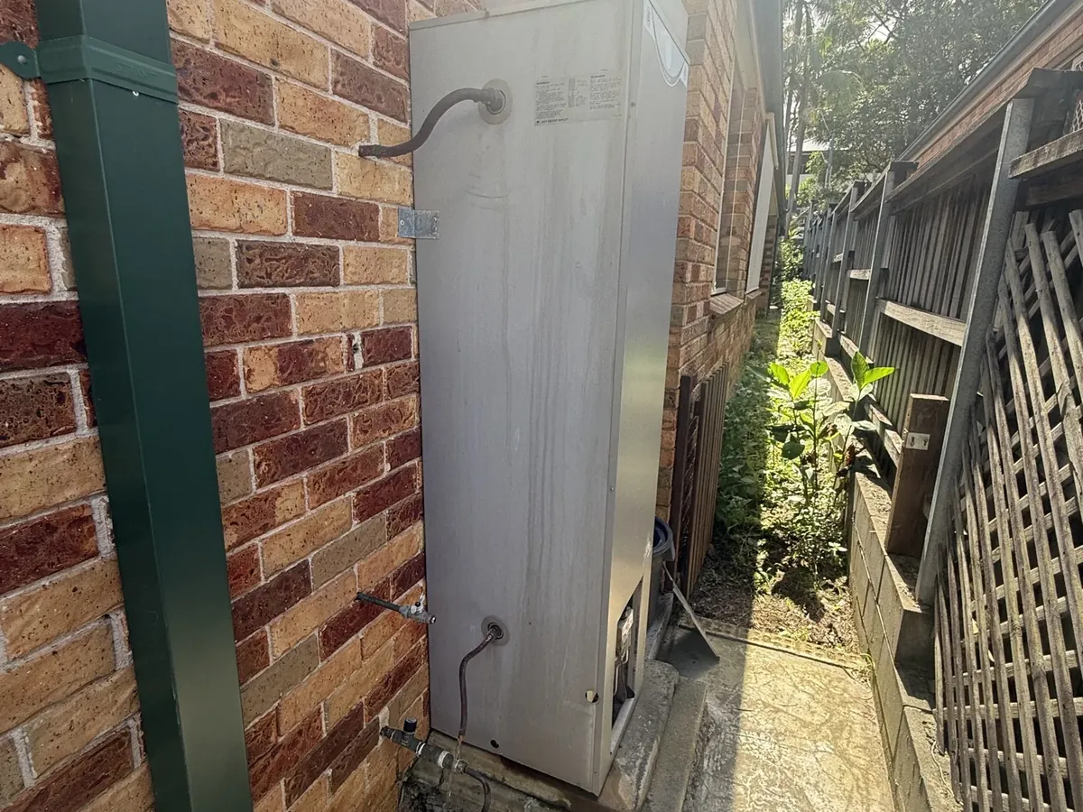 Water streaks down the casing of an outdoor gas storage hot water system