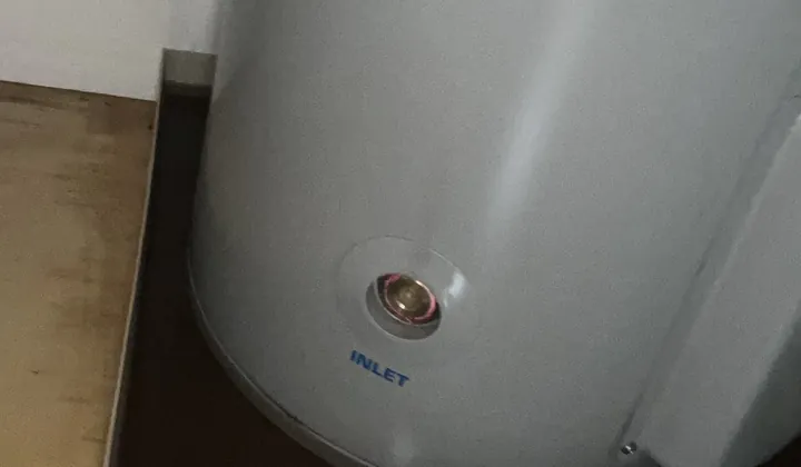 Electric hot water tank standing in a safe tray inside a cupboard in Randwick