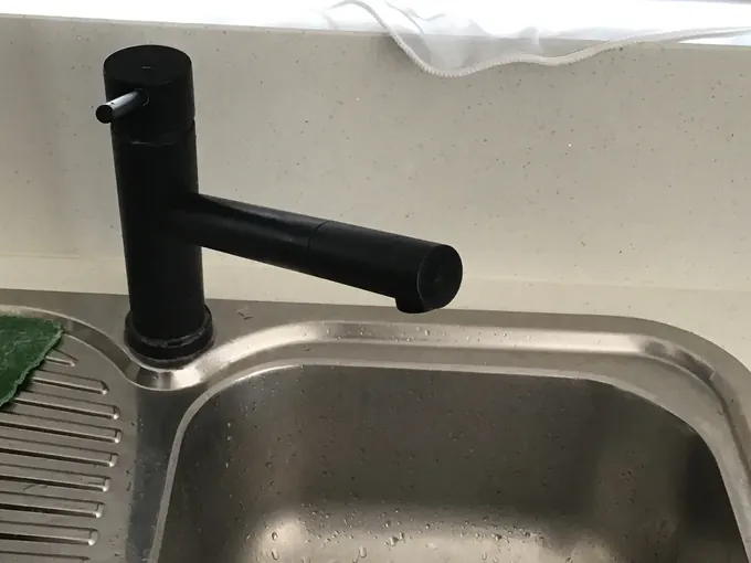 Black kitchen mixer tap over a stainless steel sink in Mount Druitt