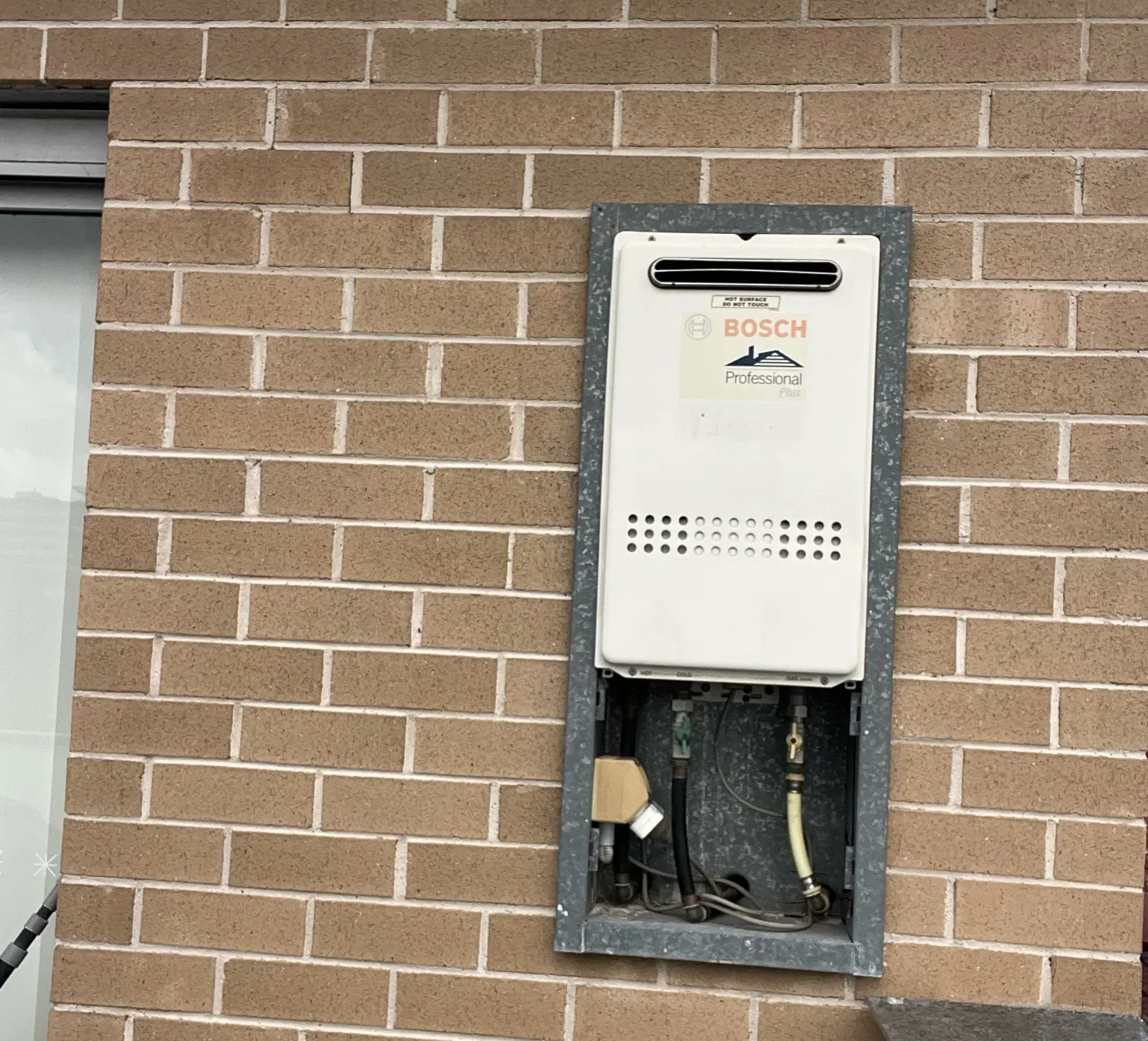 Bosch Professional Plus continuous flow unit in a recess box on a brick wall in Canterbury