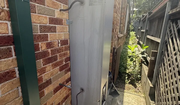 Water streaks running down the casing of an outdoor gas hot water system