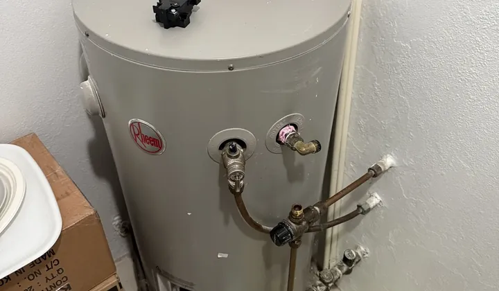 Rheem electric hot water tank with its cover off and tools laid out for testing