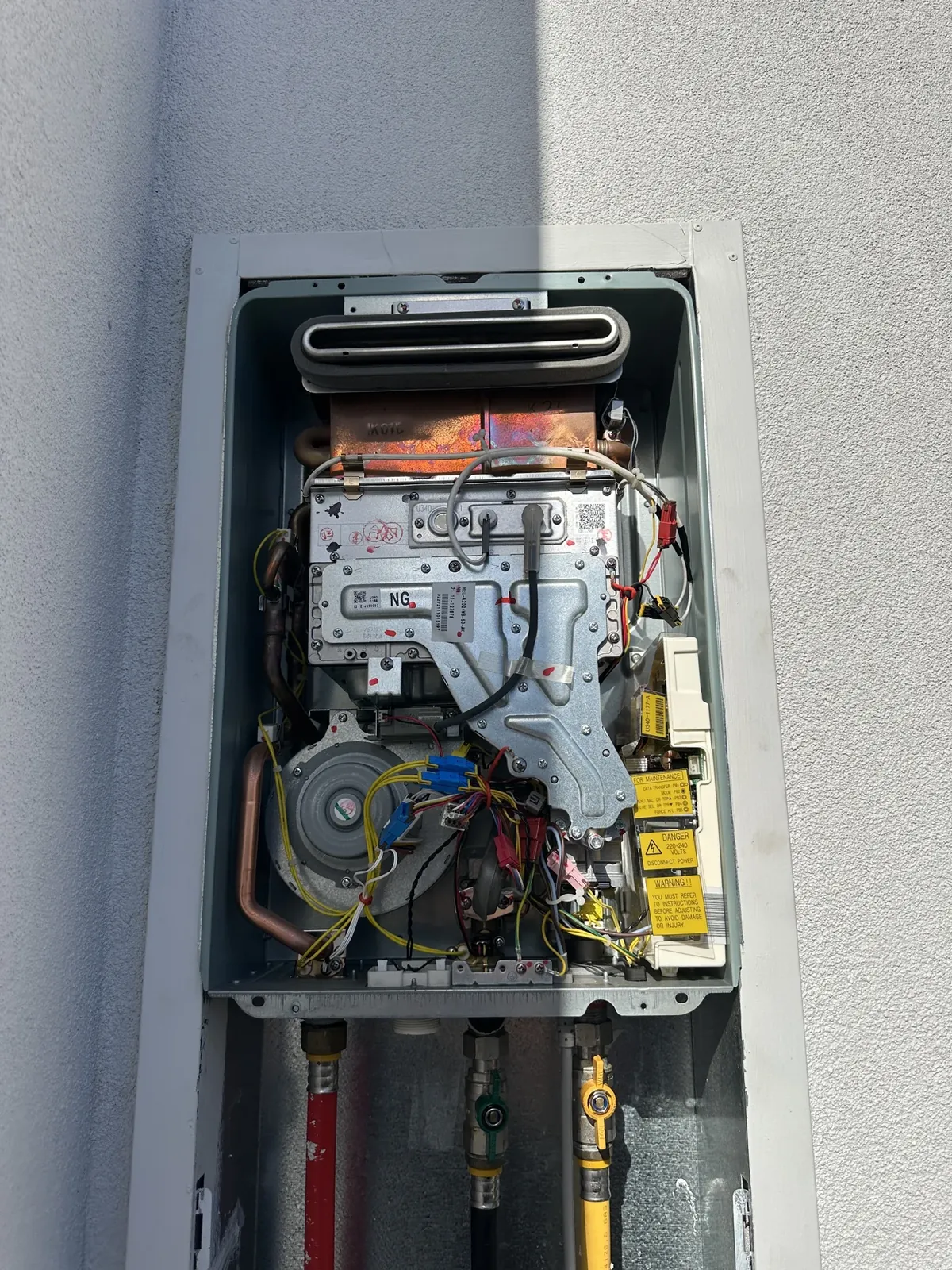 Continuous flow gas hot water unit with its front cover off for inspection