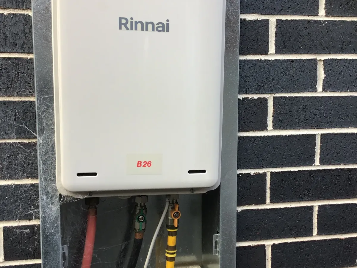 Rinnai continuous flow gas hot water unit mounted on a brick wall
