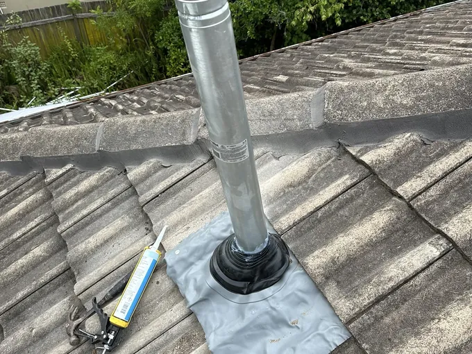 New flue pipe with flashing fitted through a tiled roof