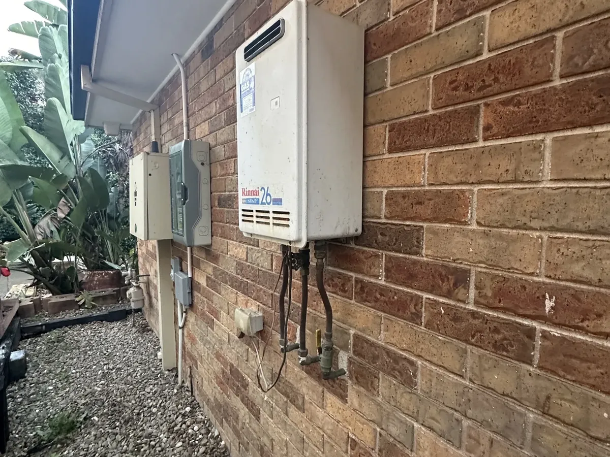 Rinnai Infinity 26 continuous flow gas hot water unit on a brick wall