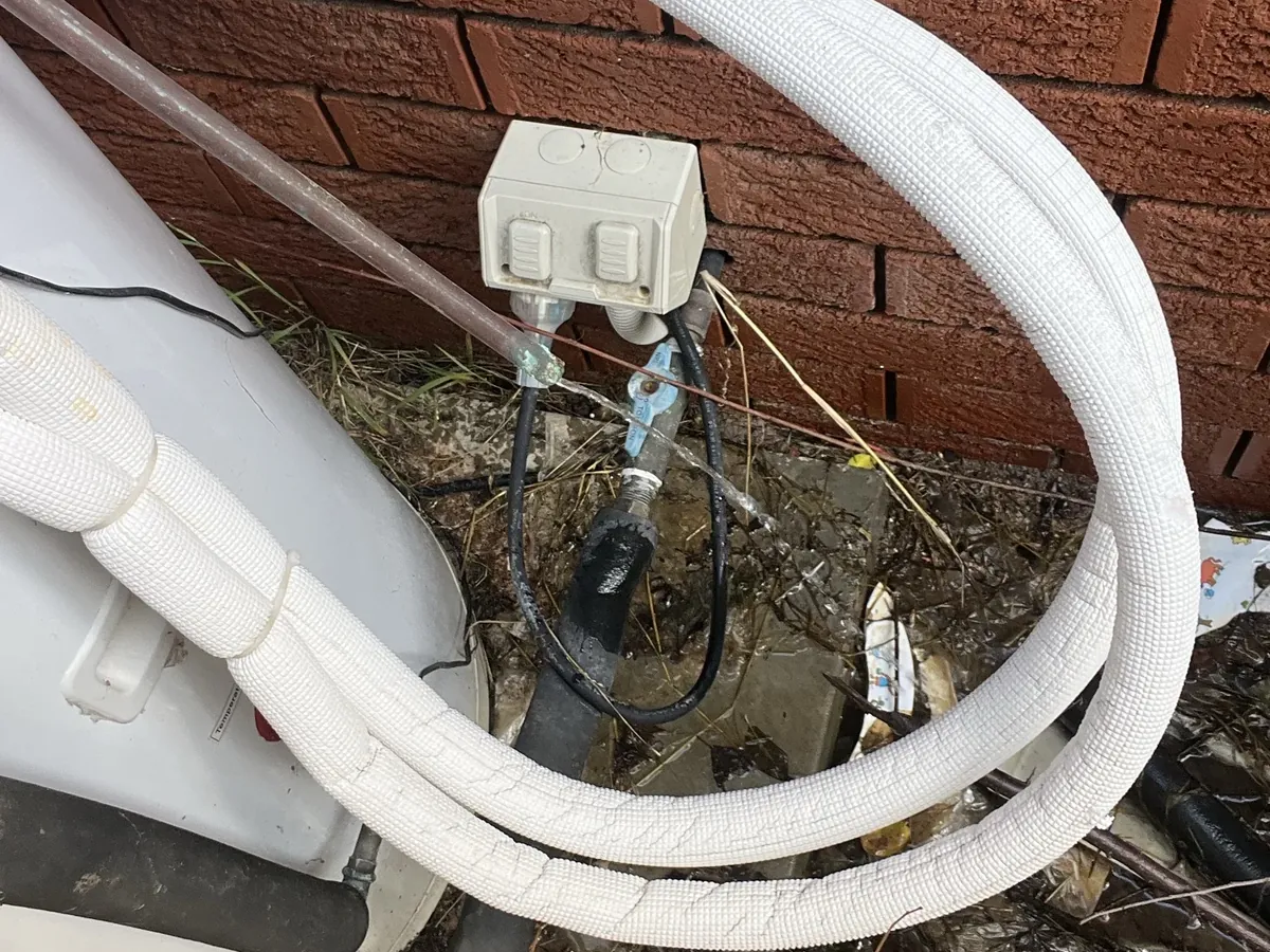 White lagged hot water pipes and a power point beside an outdoor tank in Seven Hills