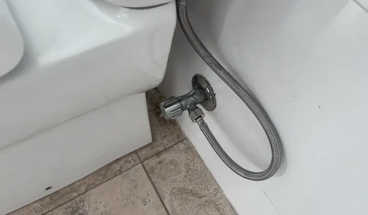 Toilet stop tap and braided flexi hose beside a toilet in Bondi Beach