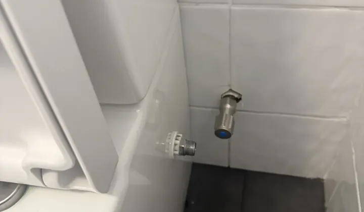 Toilet water supply stop tap and fitting on a tiled wall in Panania