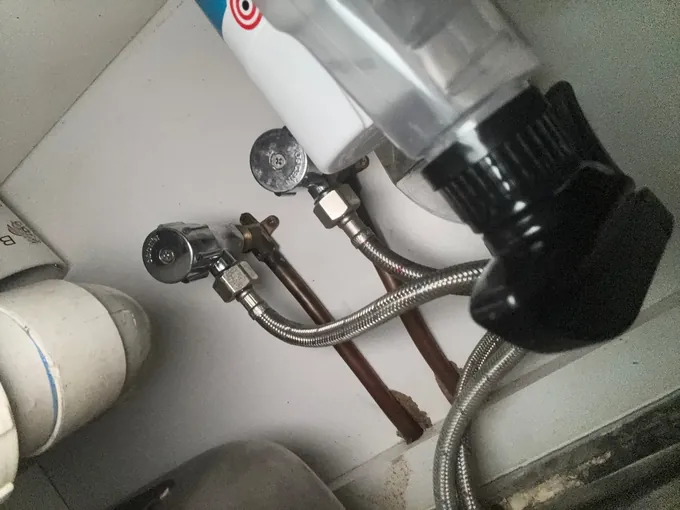 Isolating valves and braided water connections under a sink in Lakemba