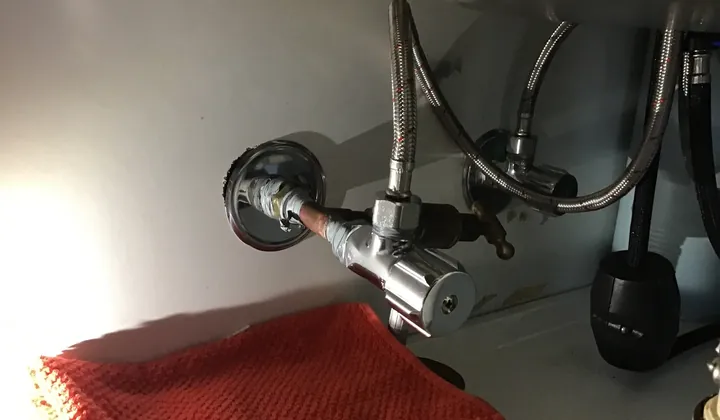 Isolation valves and braided hoses under a kitchen sink in Oxley Park