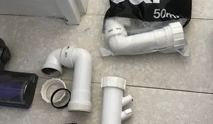 Old sink trap removed beside a new replacement trap kit in Bondi Beach